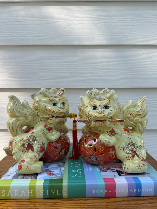 Detail view of pale yellow, coral and gold floral ceramic foo dog pair