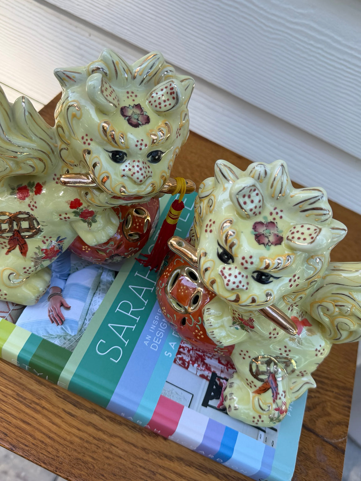 Detail view of pale yellow, coral and gold floral ceramic foo dog pair