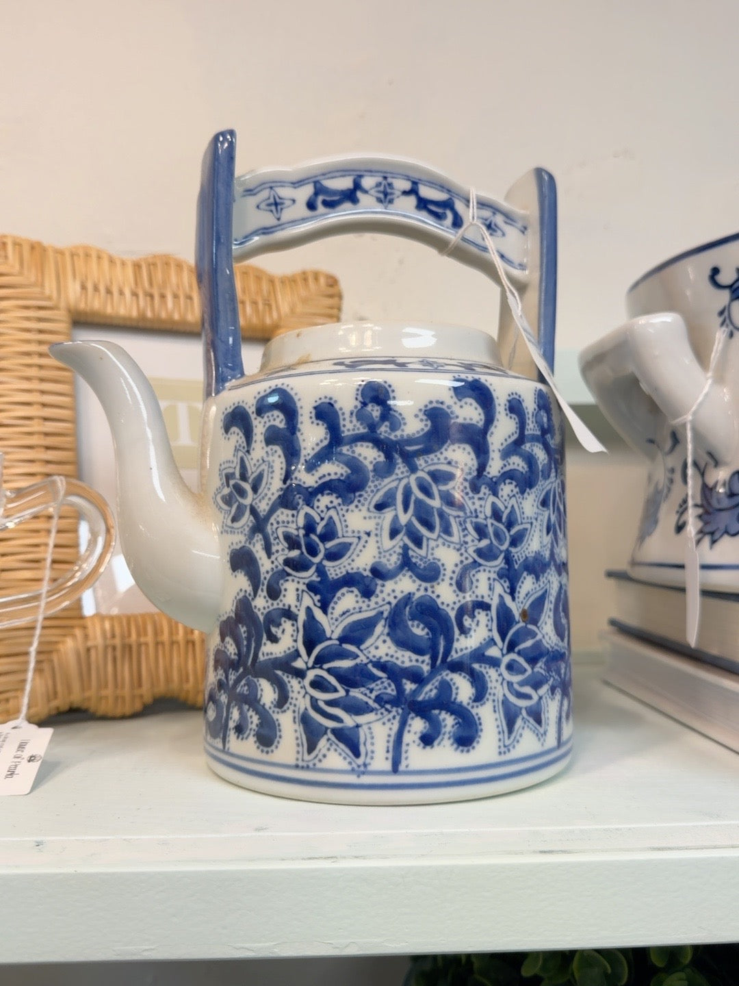 Blue-and-white floral ceramic teapot with tall arched handle