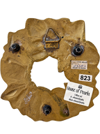 Reverse of brass wreath trivet with feet, hanging bracket and Made in India label