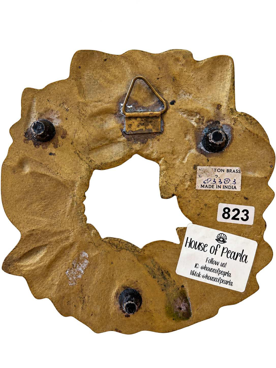 Reverse of brass wreath trivet with feet, hanging bracket and Made in India label