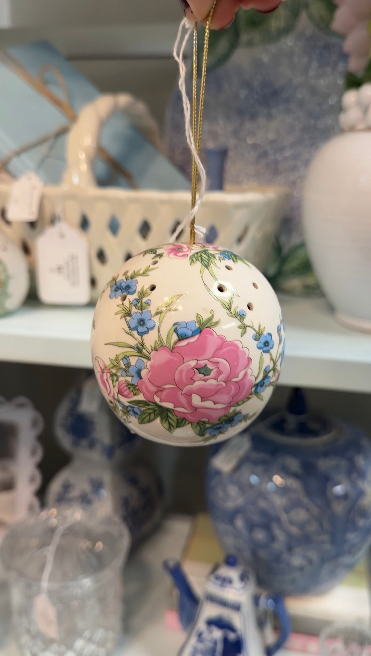 Porcelain potpourri ball with pink and blue flowers, green leaves, and a gold hanging cord