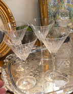Front view of four crystal martini glasses on a silver tray