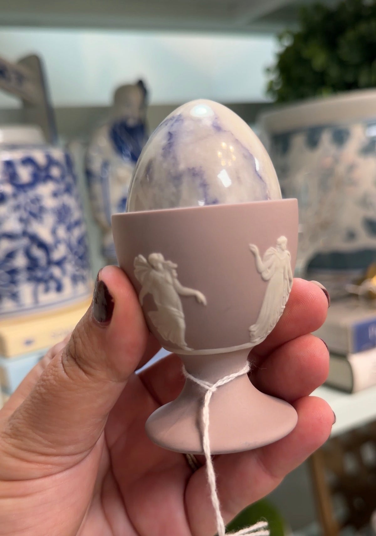 Lavender Wedgwood egg cup with white classical relief figures and a polished marble egg