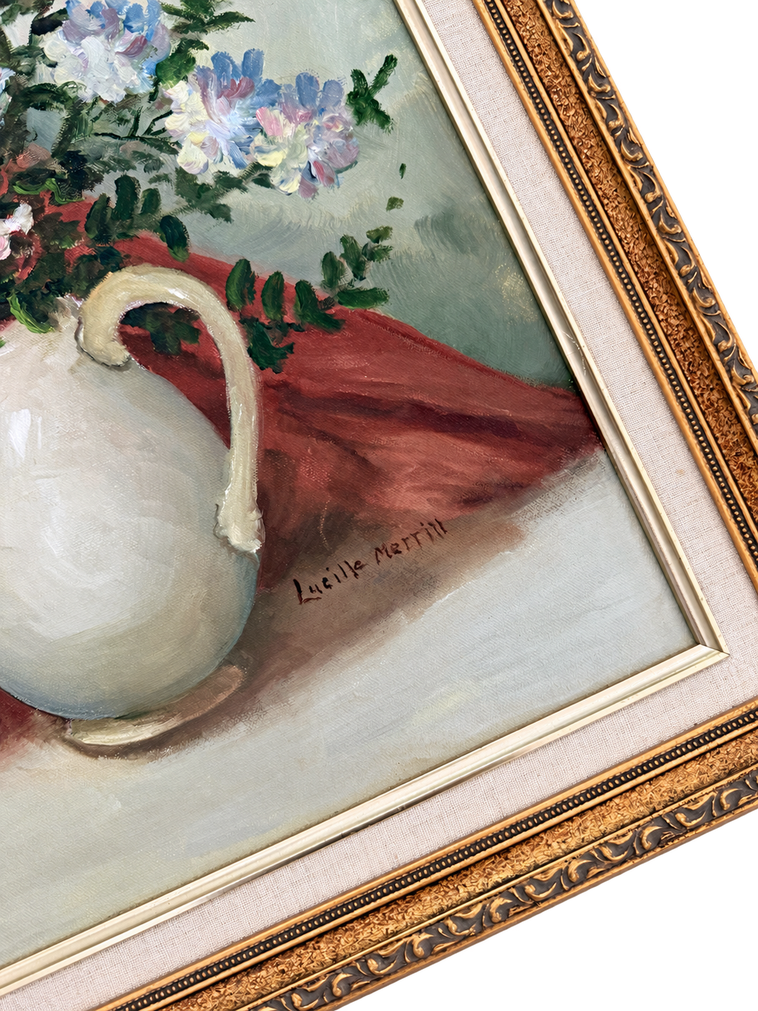 Close-up of floral still life showing the Lucille Merrill signature, canvas texture, cream liner, and ornate gold frame