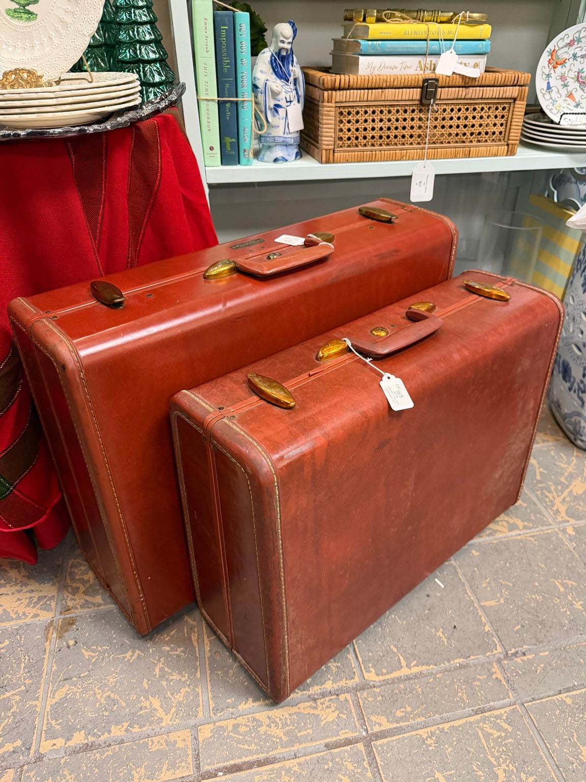 Larger vintage cognac-brown suitcase at the back and smaller suitcase in front, sold separately