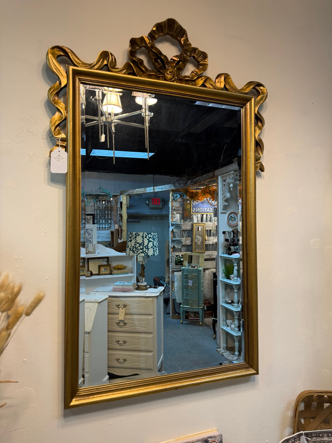 Vintage rectangular gold-tone wall mirror with a sculpted bow crest and flowing ribbon details